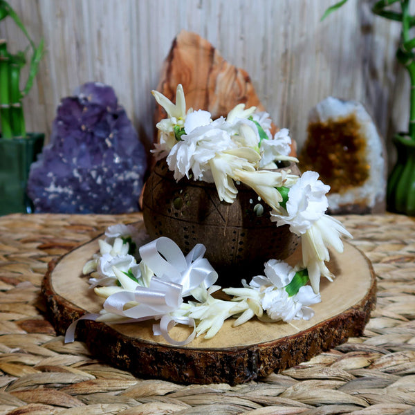 kupaloke flowers on a wooden base with colored rocks in the background
