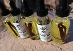 Five bottles of vanilla beard oil with droppers on a stone surface.